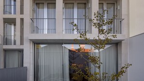 Een modern gebouw met een platte gevel, grote ramen en balkons.