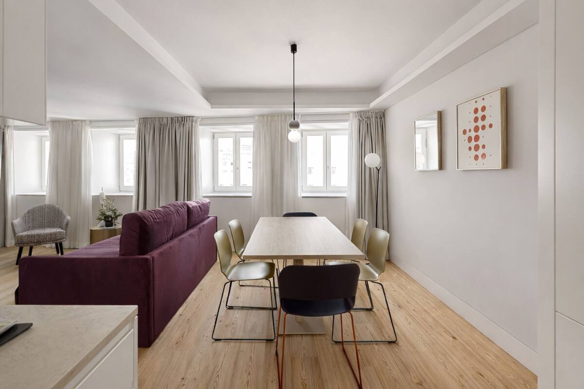 Una sala moderna con una mesa grande, un sofá y una silla.