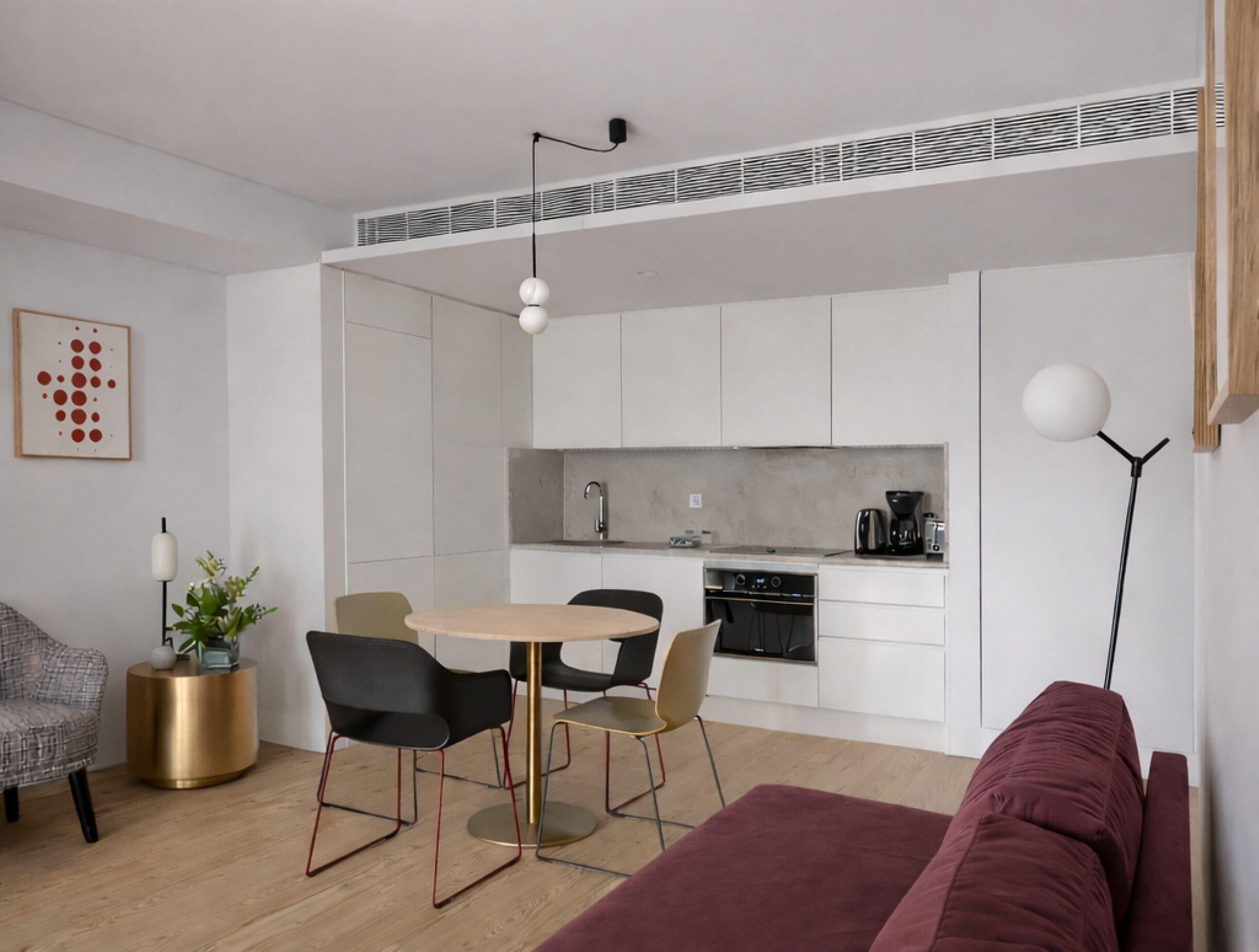 A modern living space with a dining area, kitchen, and seating area.