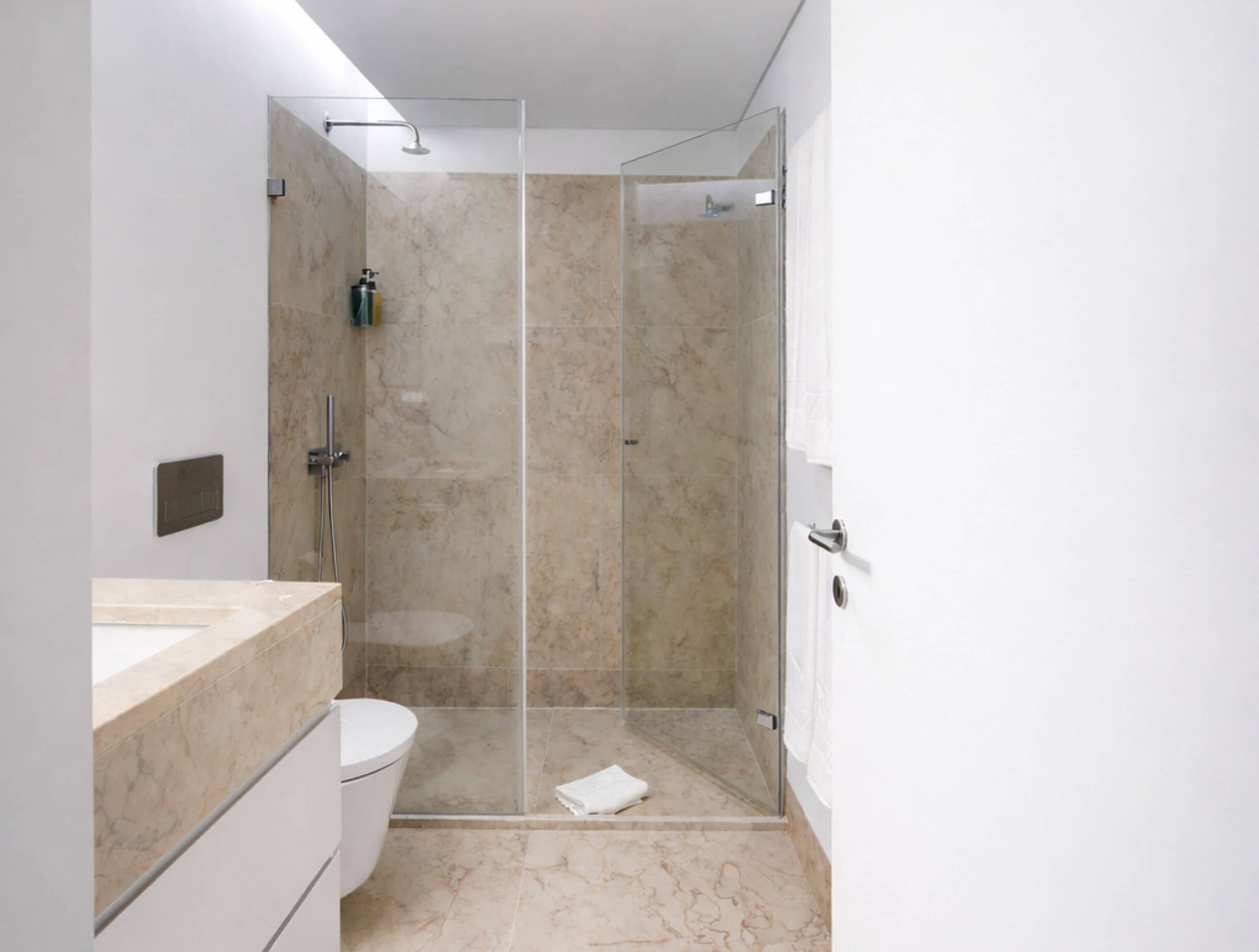 Ein modernes Badezimmer mit einer Duschkabine, einer Toilette und einer Marmorarbeitsplatte.