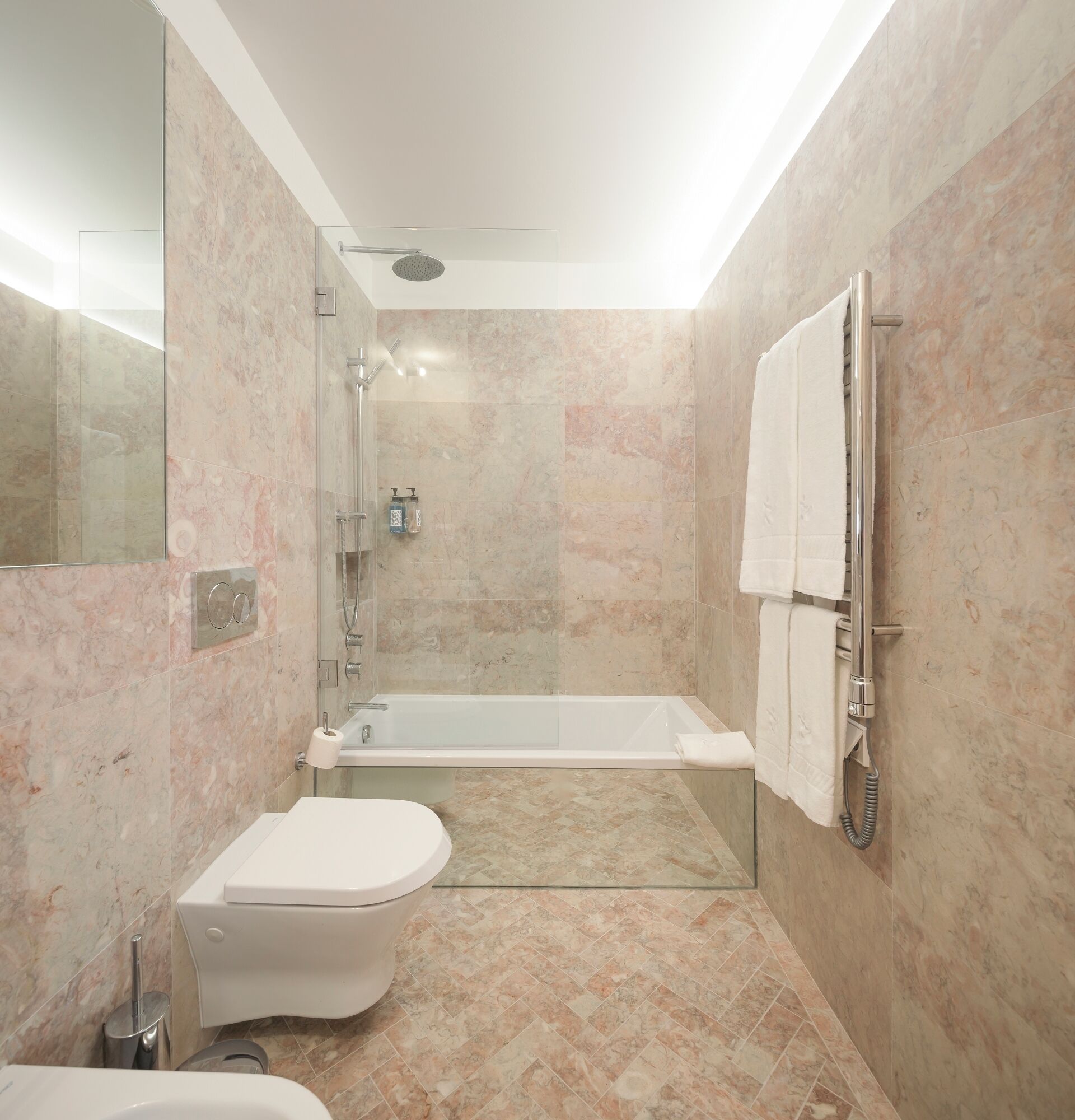 A modern bathroom with a glass-enclosed shower, a standalone bathtub, and a toilet.