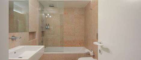 Un baño moderno con ducha, bañera y dos lavamanos.