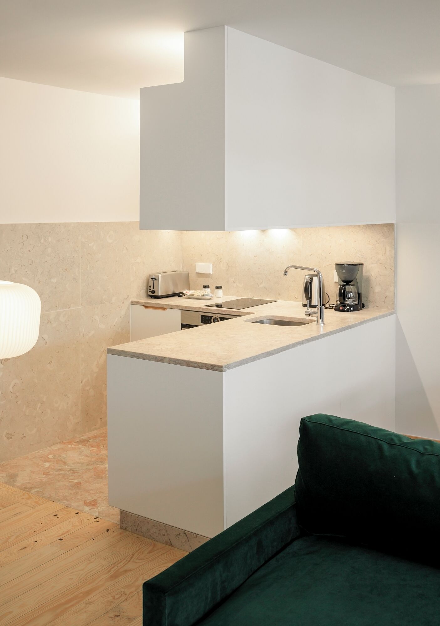 Una cocina compacta con encimera, fregadero y cafetera.