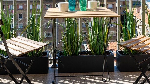 A balcony with a table, chairs, and potted plants. - La Belle Vue - 65m2 au dernier étage avec ascenseur (Marseille)