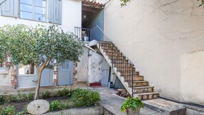 A staircase leading to a building with a rustic exterior, a tree, and a potted plant. - La Petite Provence - Two Bedroom House, Sleeps 4 (Marseille)