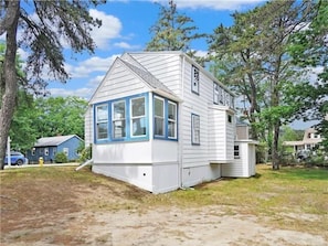 Une maison de plain-pied avec un toit à pignon, une véranda à l’avant et un garage.