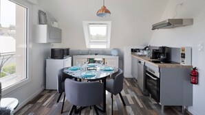 A compact kitchen with a dining area, a built-in microwave, a coffee maker, and a fire extinguisher.