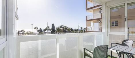 A balcony with a view of palm trees and a clear sky.
