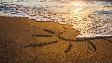 En la playa, playa de arena blanca, camastros y sombrillas