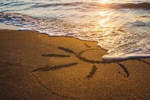 On the beach, white sand, sun-loungers, beach umbrellas