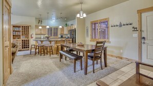 A spacious kitchen with wooden cabinets, a dining area with a table and chairs, and a cozy seating area with a sofa.