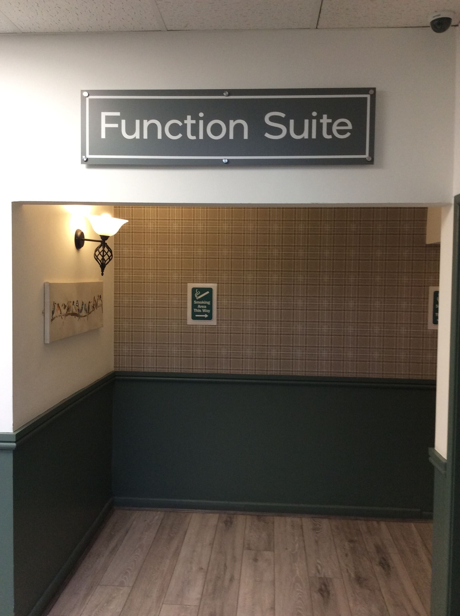 Un pasillo con un letrero que dice 'Function Suite' sobre una pared de azulejos.