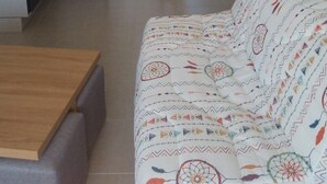 Ein kompakter Wohnbereich mit Küchenzeile, einer Couch und einem Esstisch.