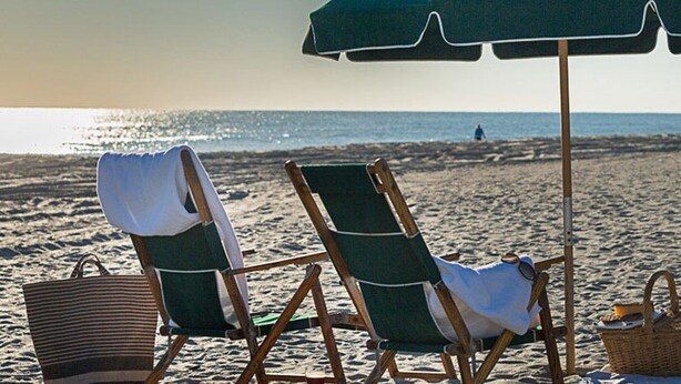 Two beach chairs under an umbrella, a wicker basket, and a wooden fence in the background. - Villa with Great Ocean View (Atlantic Beach)