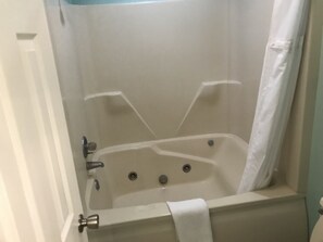 Tina con regadera, toallas, papel de baño 