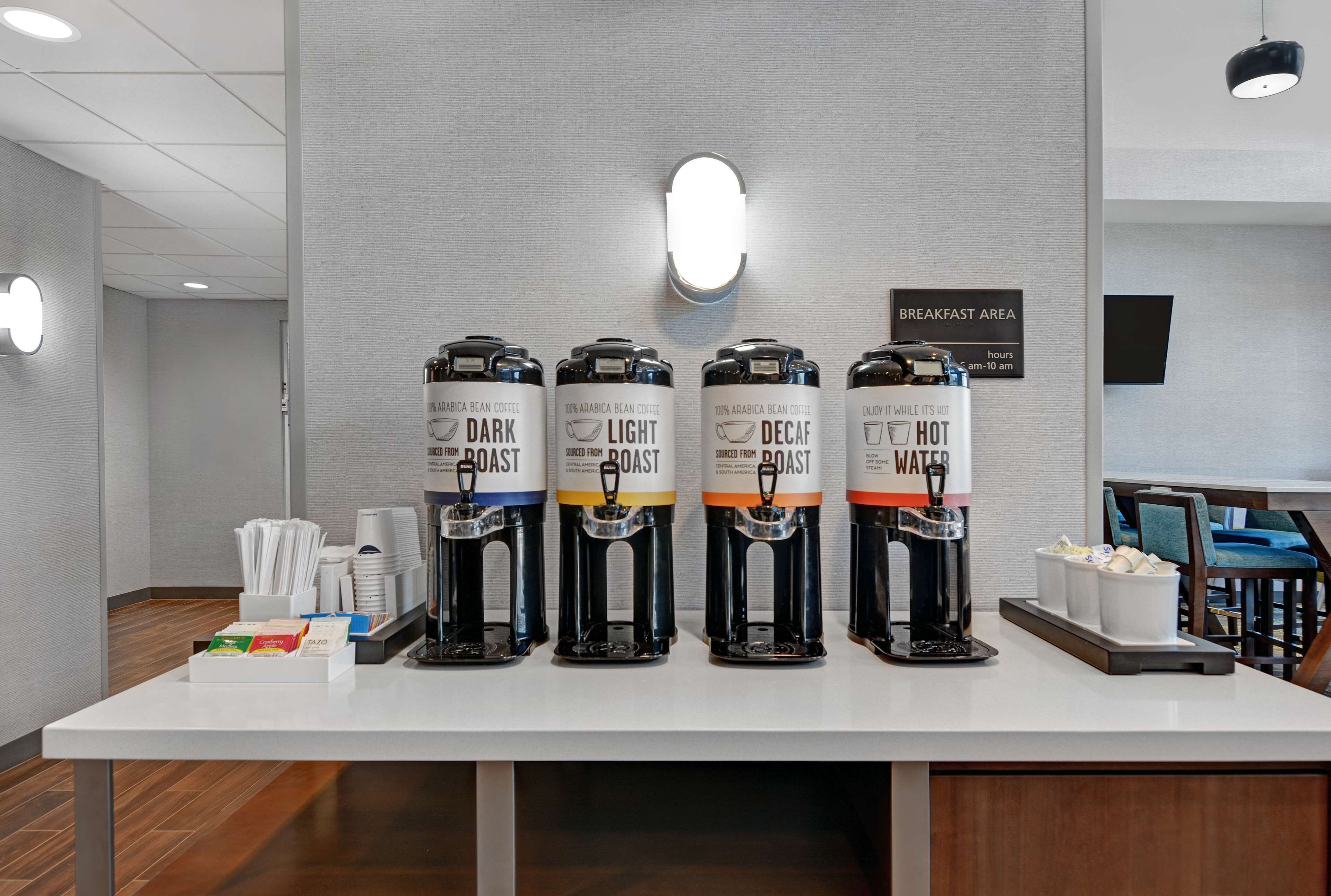 A coffee station with four coffee dispensers labeled DARK, LIGHT, DECAF, and HOT.
