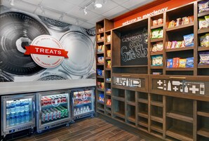 Una sección de aperitivos y bebidas con refrigerios y estantes llenos de productos.