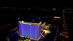 Edificio di un Holiday Inn Express dal design moderno, con illuminazione verticale e una segnaletica ben visibile.