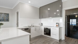 Eine moderne Küche mit weißen Schränken, einem Backofen und einem Geschirrspüler.