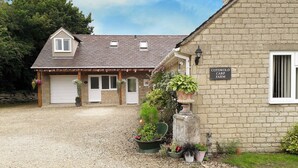 Un bâtiment en pierre sur lequel est apposée une enseigne indiquant : « Ferme piscicole de Cotswold ».
