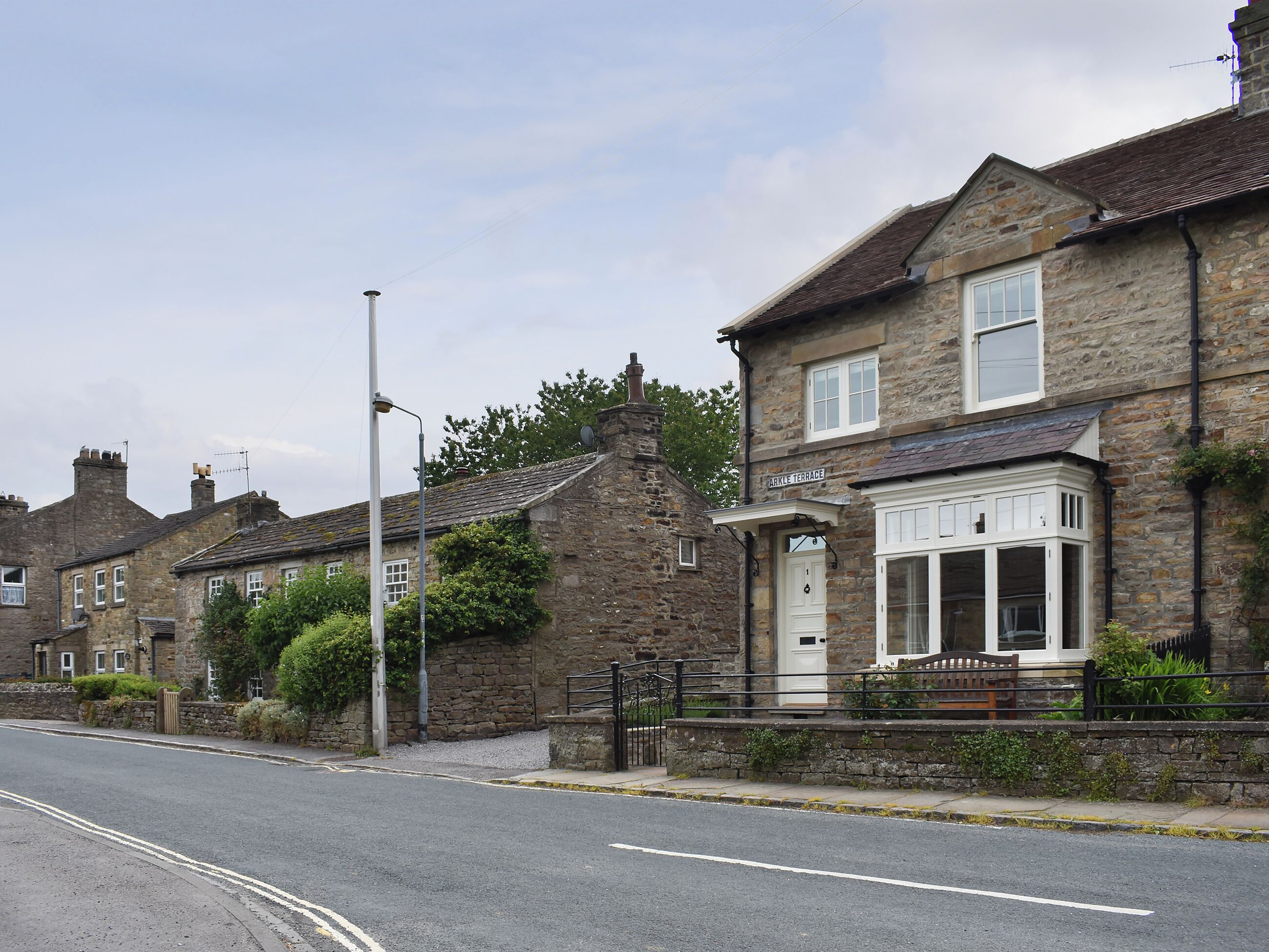 A row of stone houses with a street in front, including a building labeled 'ARKLE TERRACE.'