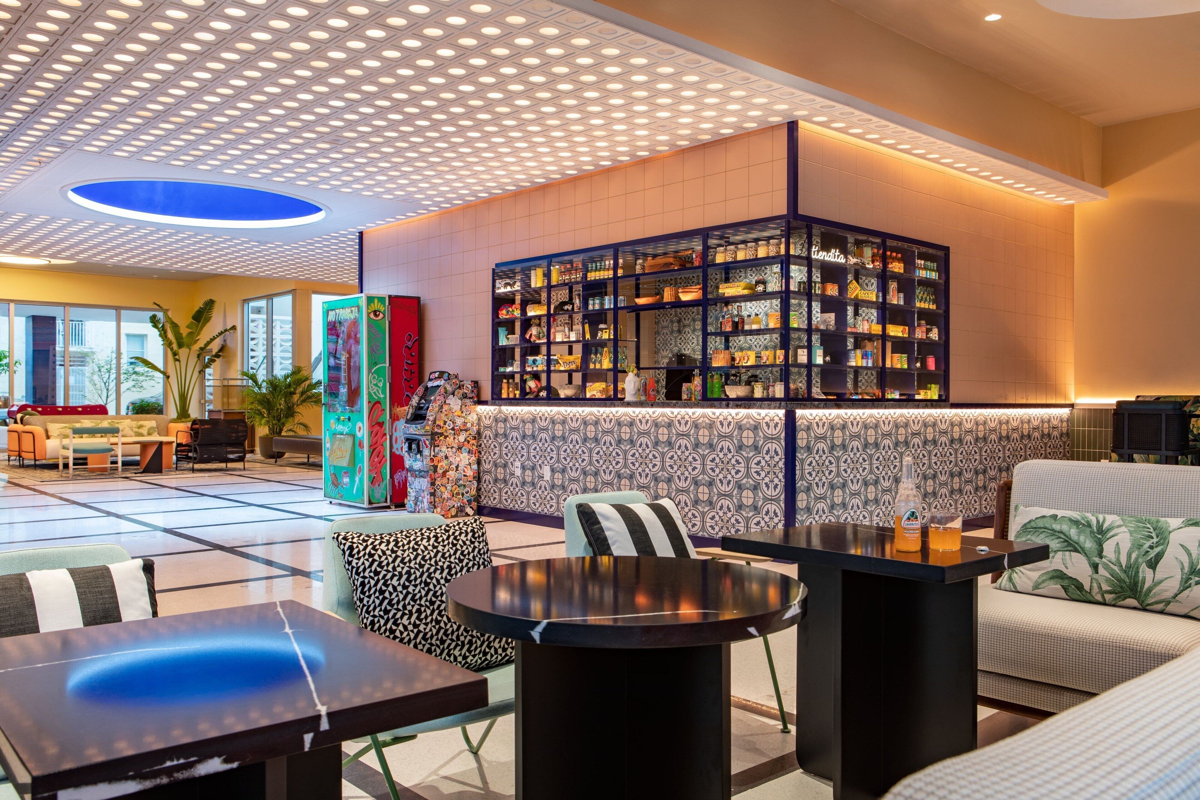 Een moderne lobby met een centraal ziteiland, een behangwand en een presentatie van diverse producten.