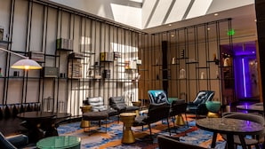 A spacious lounge area with a high ceiling, skylights, and modern furniture. - Canopy by Hilton Memphis Downtown (Memphis)