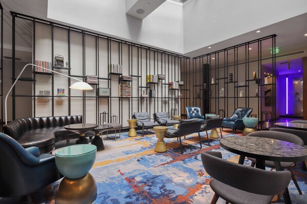 Un espace de détente moderne avec des canapés en cuir, des tables rondes et un tapis à motifs.