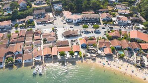 Μια αεροφωτογραφία μιας παραθαλάσσιας πόλης με μαρίνα, παραλία και οικιστικά κτίρια.
