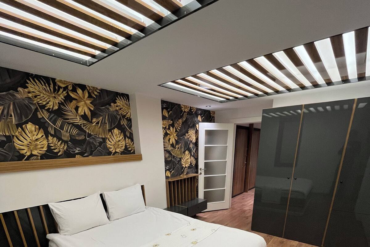 Une chambre à coucher moderne avec un grand lit, une armoire et un mur décoratif.