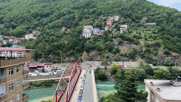 Un puente rojo sobre un río, con edificios en la ladera al fondo.