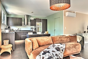 A modern kitchen with dark cabinets, a central island, and a dining area.