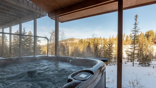 A hot tub with a view of a snowy forest. - Summit Trails Lodge: Cozy, Hot Tub, Trail Access (Lead)