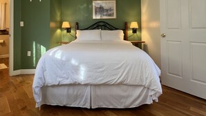 Un dormitorio con cama, dos lámparas de noche, un ventilador de techo y una puerta.