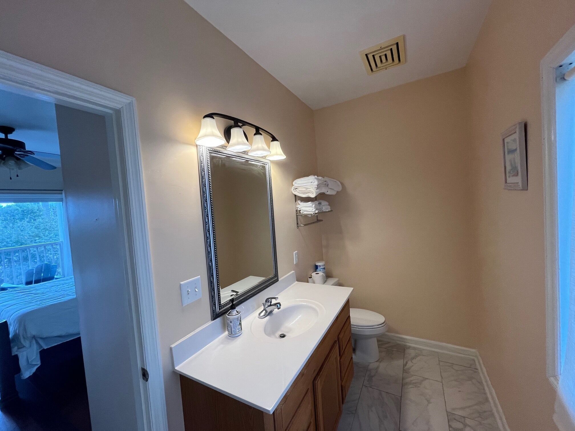 A bathroom with a white sink, a large mirror, and a toilet.
