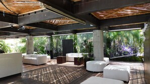 A modern outdoor lounge area with white sofas and a wooden deck. - Hotel & Spa Luna Canela Boutique (Atlixco)