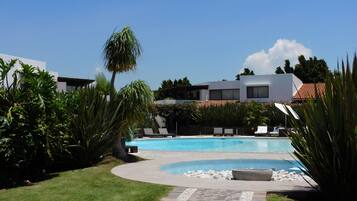 حمّام سباحة خارجي، مظلات على حمّام السباحة، مقاعد للتشمس