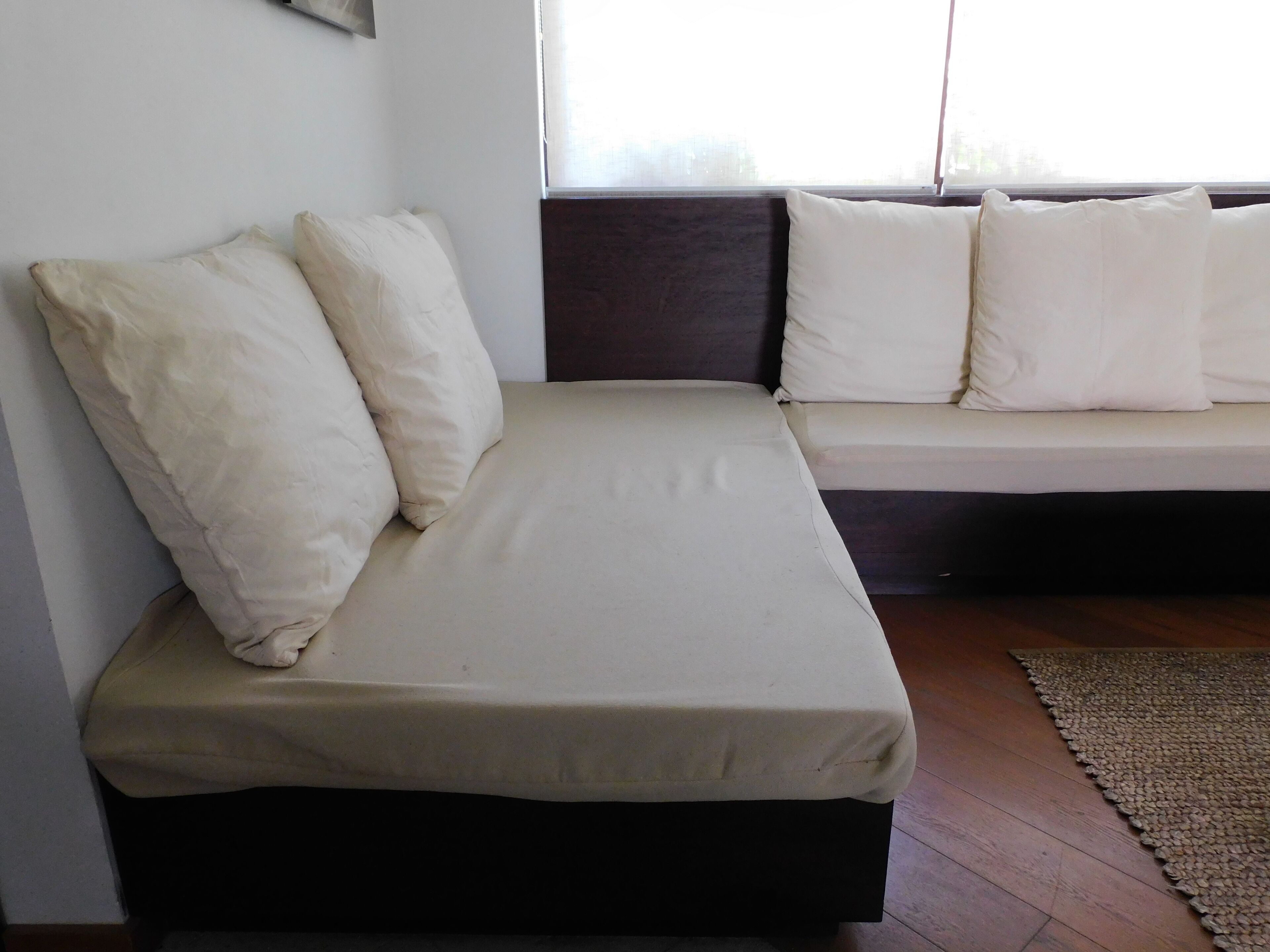 Habitació petita amb un llit individual, un panell de capçaleri fosc i roba de llit blanca.