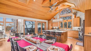 A spacious kitchen with wooden cabinets, a large island, and a dining area set for a meal.