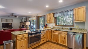 A modern kitchen with wooden cabinets, stainless steel appliances, and a granite countertop. - Kentucky Deer Run- Wheelchair Accessible, Lakefront, Private Dock, Fully Updated (Benton)