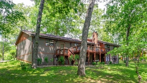 A two-story house with a wooden deck, surrounded by trees and a well-maintained lawn. - Kentucky Deer Run- Wheelchair Accessible, Lakefront, Private Dock, Fully Updated (Benton)