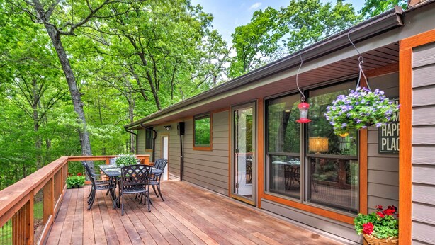 A wooden deck with a table and chairs, surrounded by a wooden railing. - Kentucky Deer Run- Wheelchair Accessible, Lakefront, Private Dock, Fully Updated (Benton)