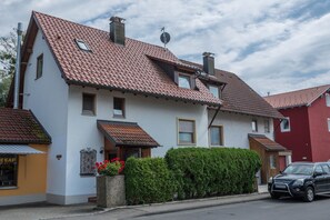 A two-story house with a red-tiled roof, a chimney, and a small window. - Cozy Apartment “Konrad Schielin” with Mountain View, Wi-Fi & Balcony (Lindau)