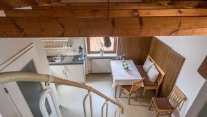 Un interno in legno con zona pranzo, cucina e scala.