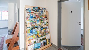 Un corridoio con una parete dedicata a brochure di viaggio e una panca in legno.