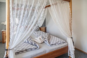 Ein Bett mit Baldachin, Kissen und einem Nachttisch.