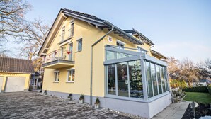 Une maison à deux étages avec un balcon, un garage et une véranda.