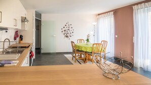 Eine moderne Küche mit Essbereich, Holzmöbeln und einem Wanddekor.