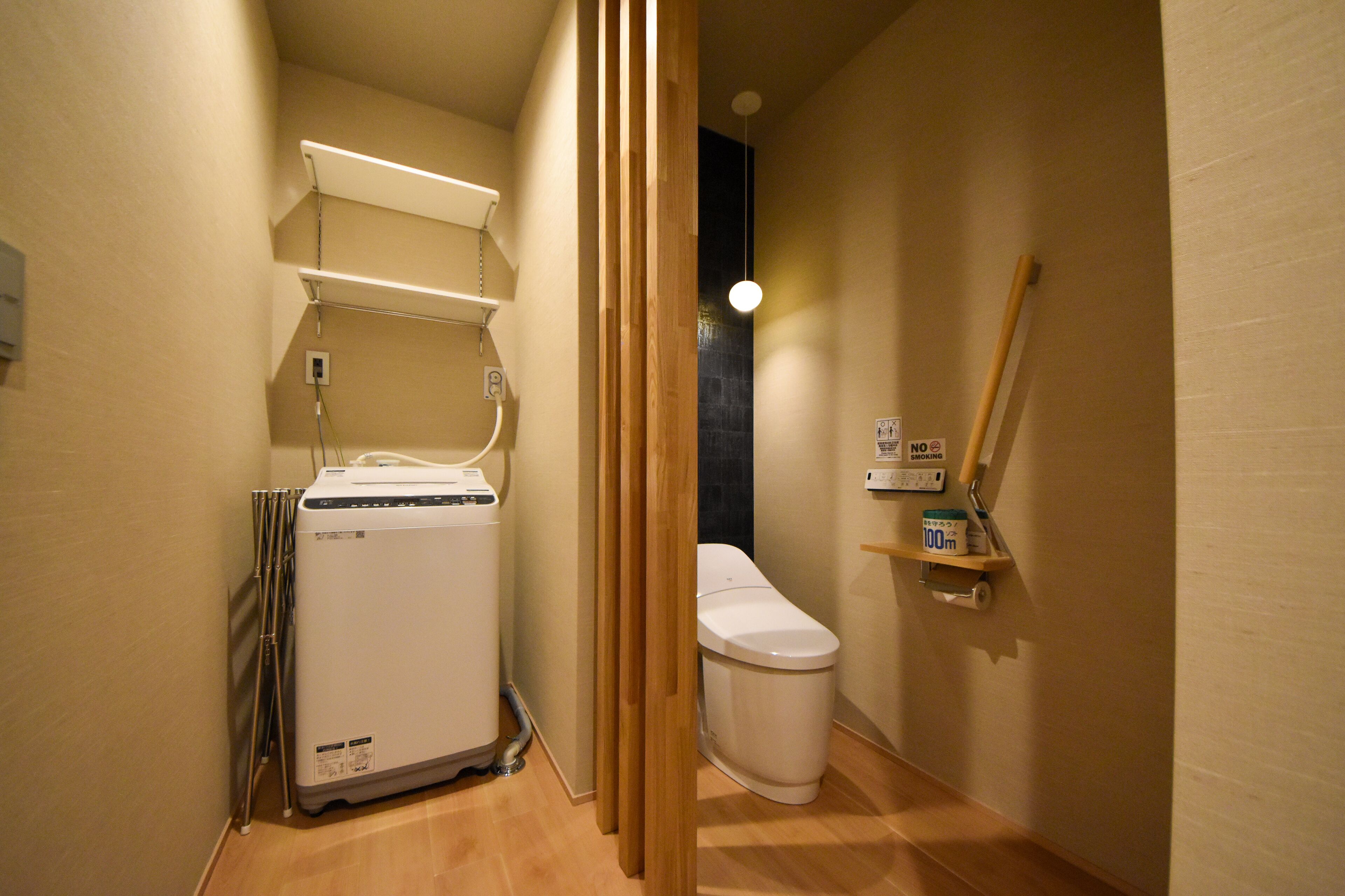 Un baño pequeño con lavadora, inodoro y un estante con productos de limpieza.