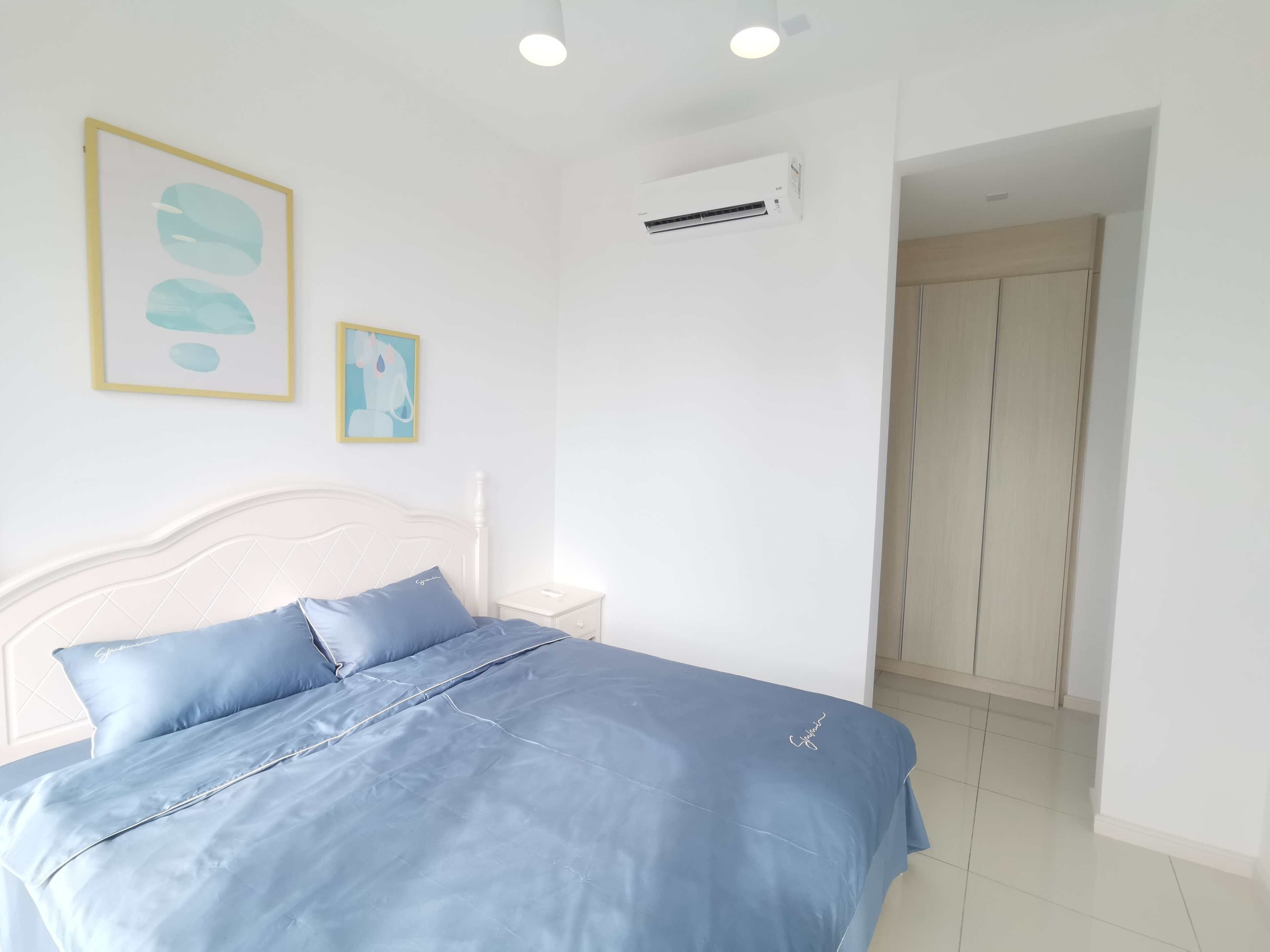 Une chambre à coucher avec un lit, une table de chevet et une armoire.